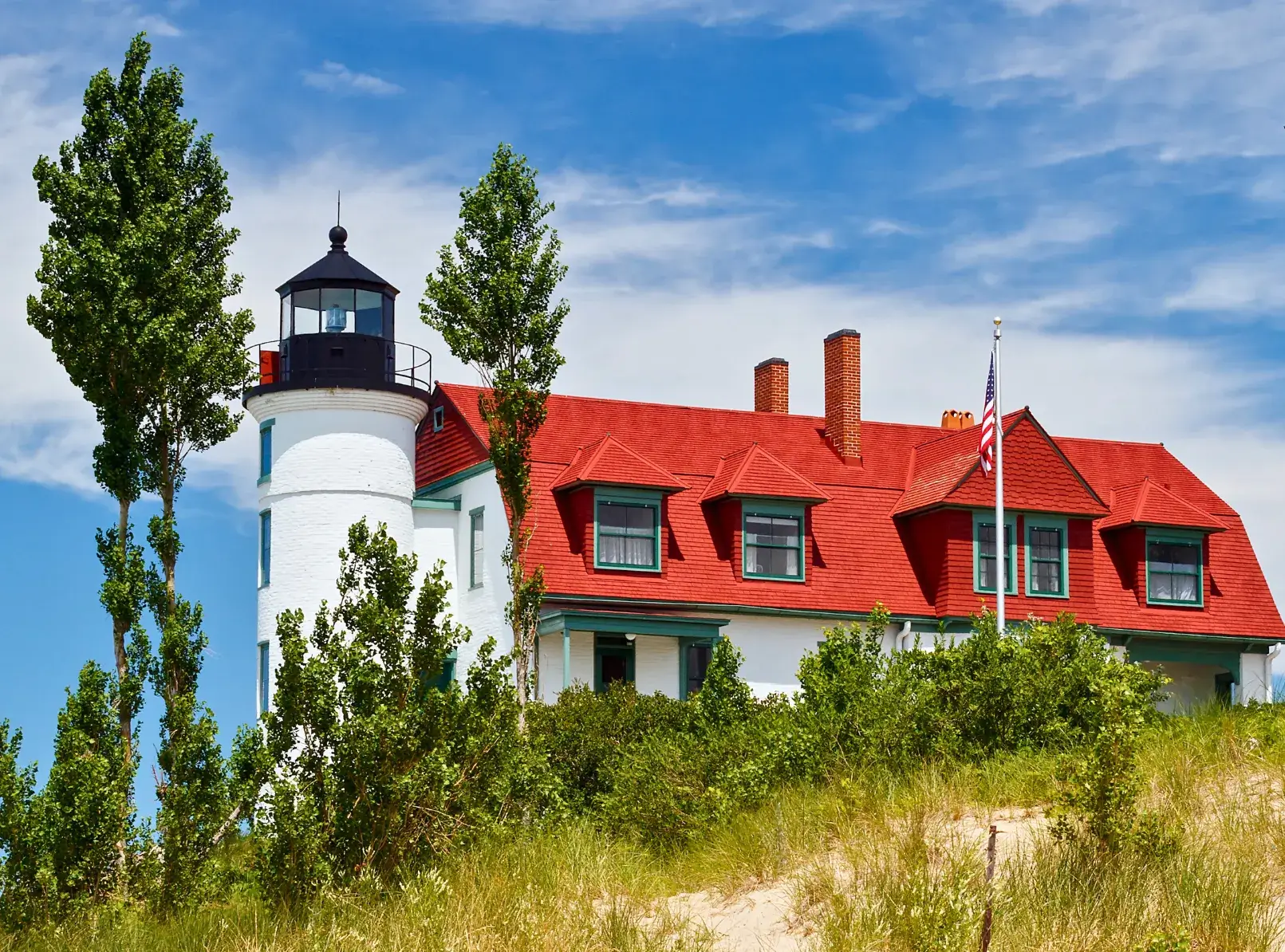 Point Betsie Lighthouse, a white tower connected to a white dwelling with a red roof and green trim.